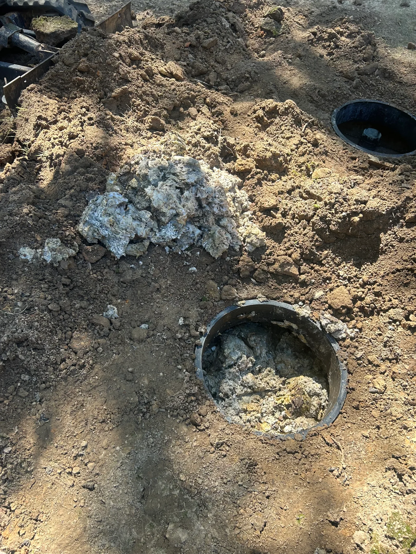 Septic tank excavation with concrete tank components and soil preparation for system installation