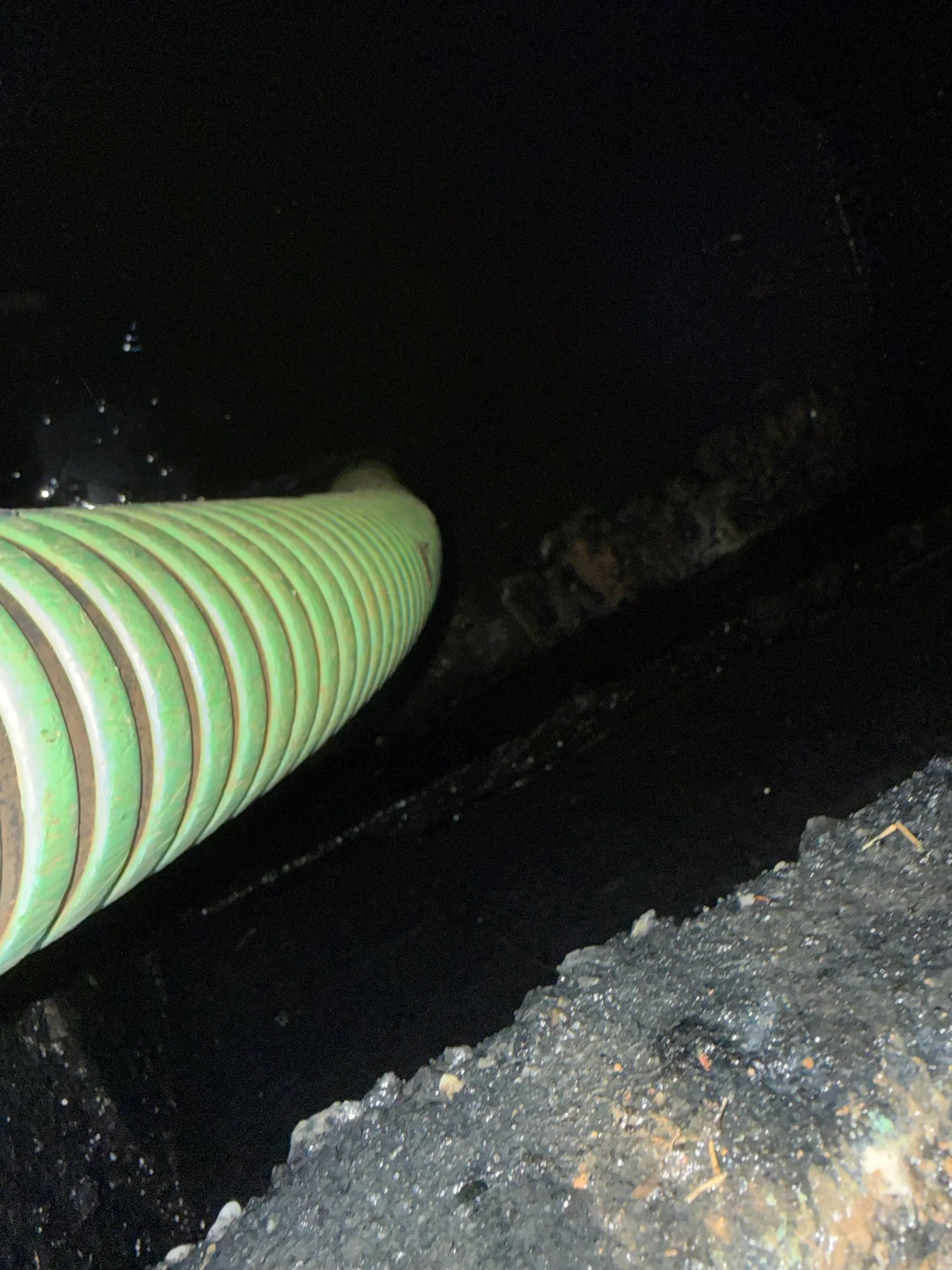 Corrugated plastic septic tank installation with reinforced ribbed design in excavated soil bed